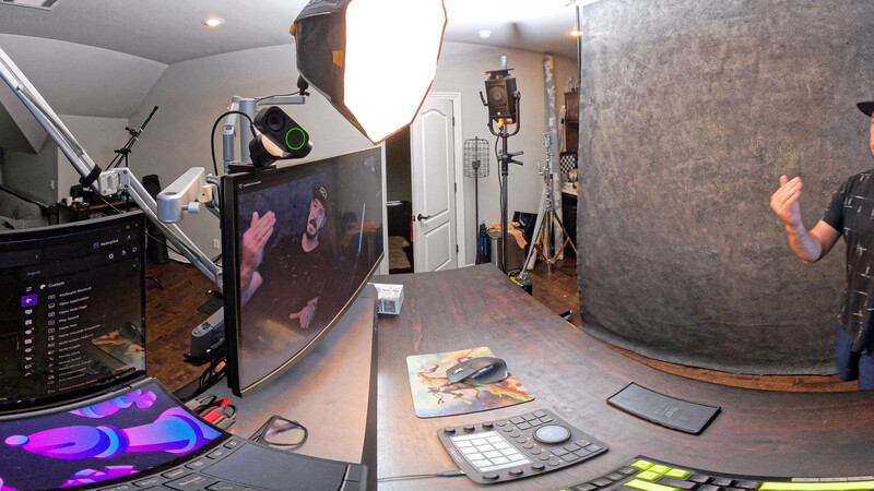 Professional video production studio setup with monitor displays, lighting rigs, and audio equipment.