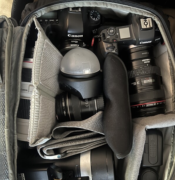 Canon DSLR camera kit packed in a gray camera bag with lenses, grip, and accessories.