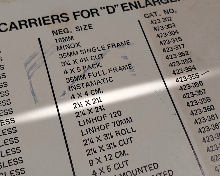 Printed reference sheet listing carriers and enlarger specifications with catalog numbers.