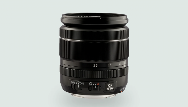 Black camera lens with focal length markings and manual focus ring against neutral background.