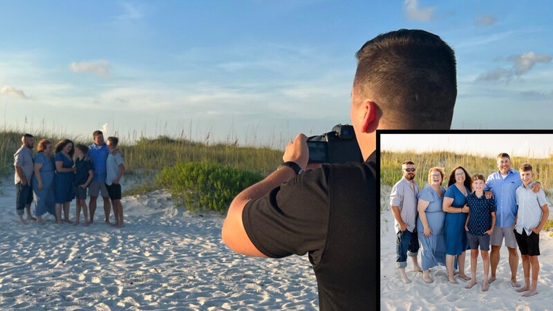 Photographer capturing a portrait of a group in blue clothing standing on a beach at golden hour.
