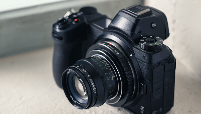Vintage manual focus lens mounted on a modern mirrorless camera body with wireless remote trigger.