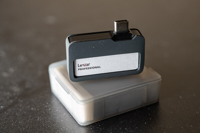 Lexar Professional memory card sitting in a white plastic case on a dark textured surface.