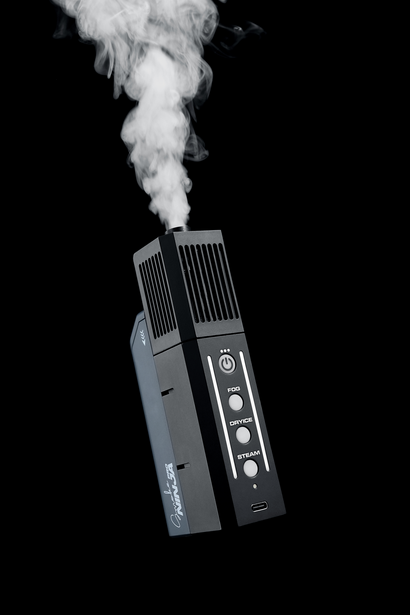 Portable vaporizer device tilted at an angle with white vapor plume rising against black background.