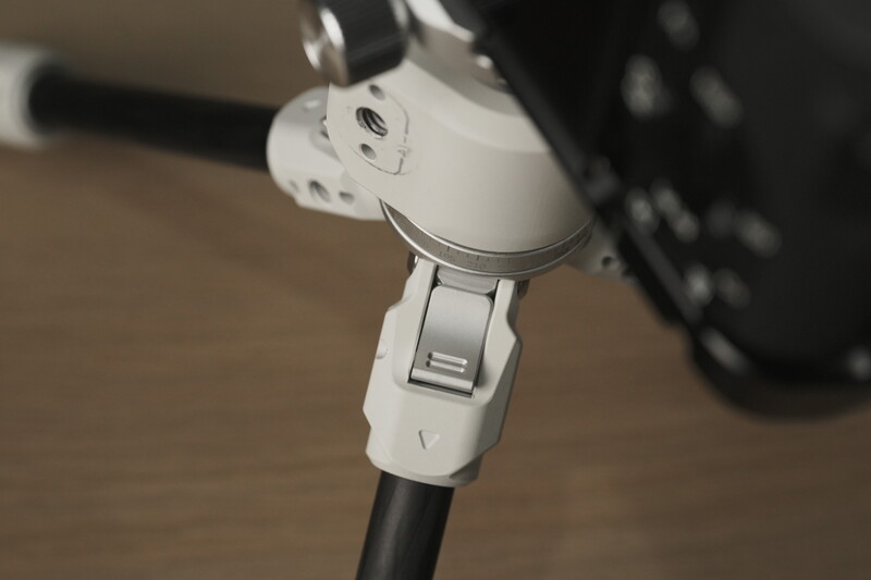 Close-up of a white electric scooter's steering column and brake lever assembly.