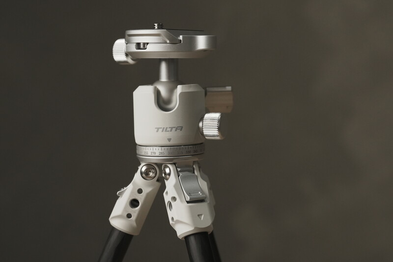 Tilta ball head tripod with white grip handles and quick-release plate against neutral background.