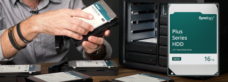 Person holding a Synology Plus Series 16TB hard drive next to an open NAS enclosure.