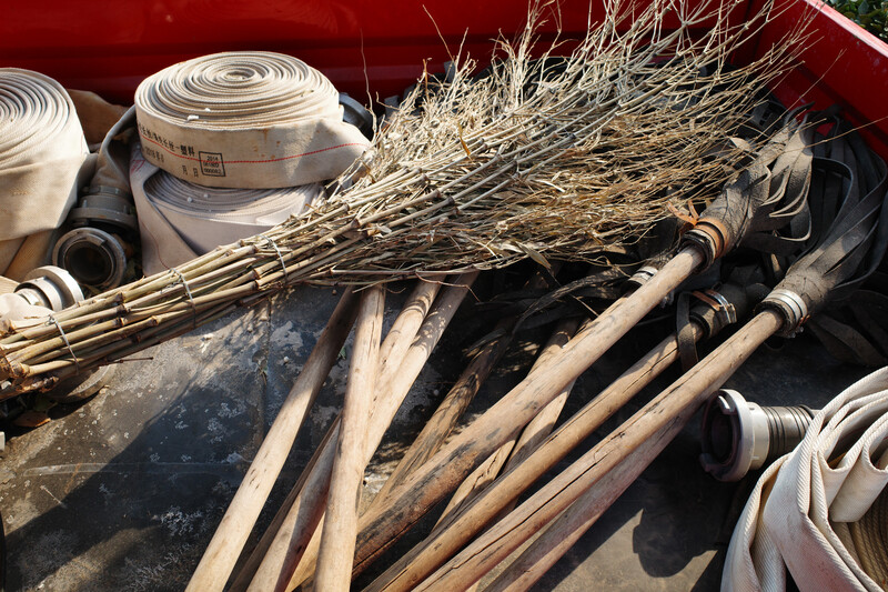 Bundle of dried grasses and natural fiber materials stored in a red container with rolls of white tape and supplies visible.