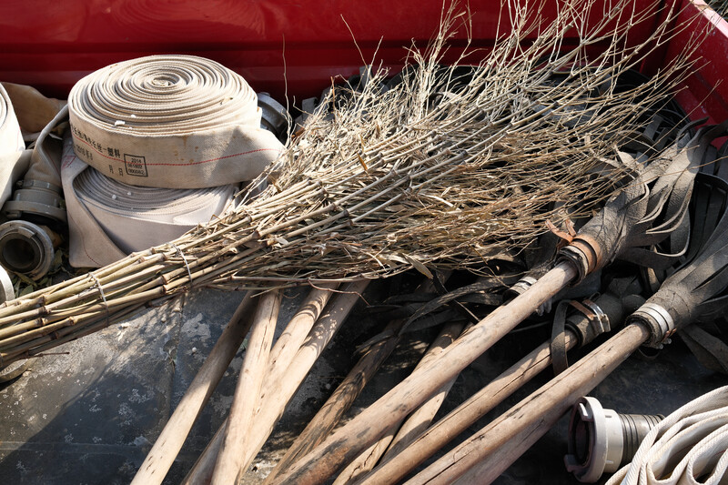 Bundled dried grasses and white PVC pipes stored in a red container.