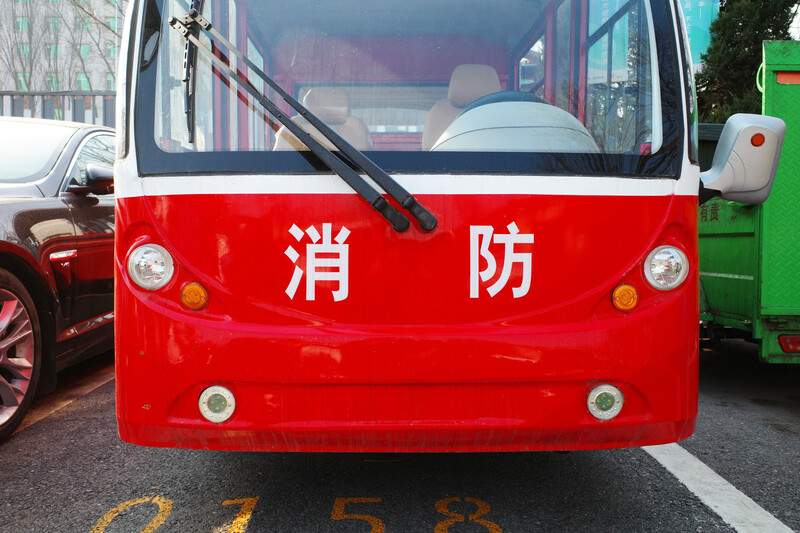 Front view of a red fire truck with Chinese characters and circular lights mounted on the bumper.