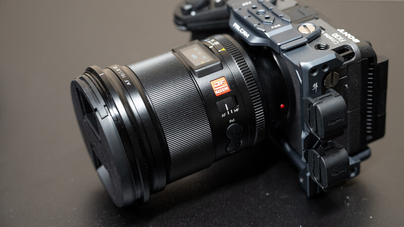 Large format camera with telephoto lens mounted on dark surface.