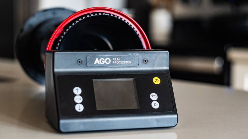 AGO film processor with red light hood and control panel featuring display screen and buttons.