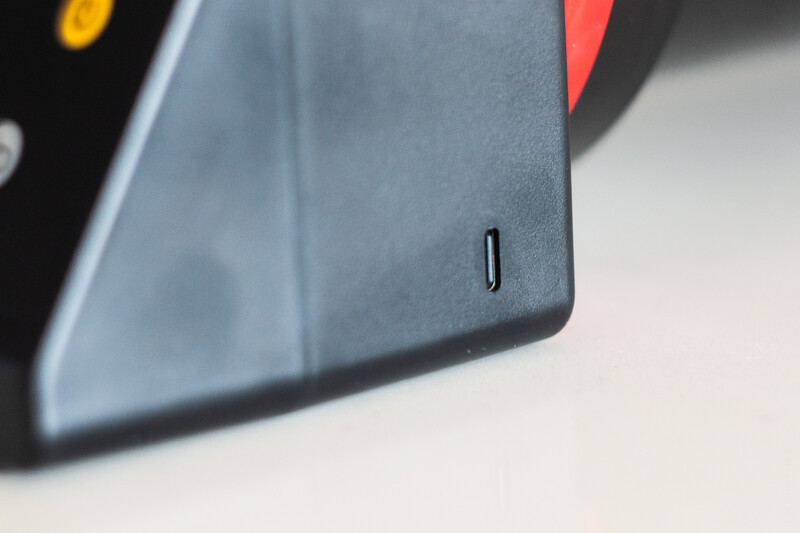 Close-up detail of a dark gray device corner with a small rectangular slot or port visible.