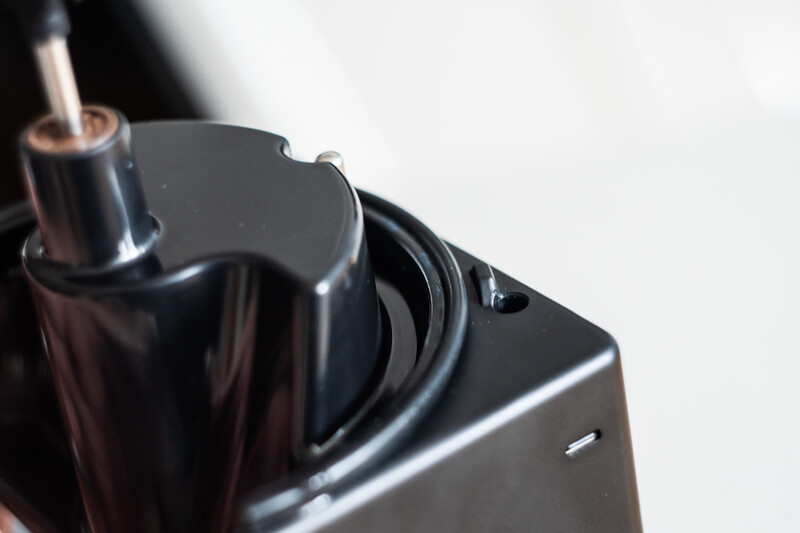 Close-up of a black camera battery charger with a power adapter jack visible against a white background.