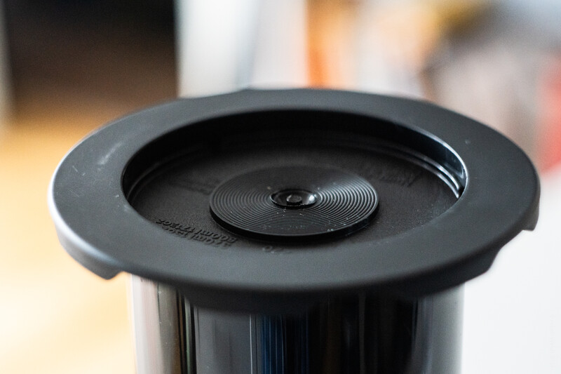 Close-up of a black circular lens hood with concentric spiral ridges and a recessed center opening.