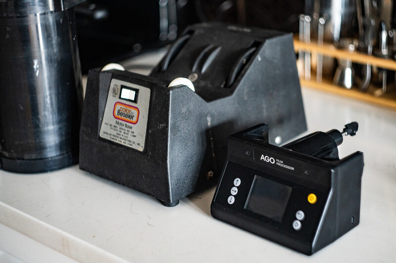 A tape dispenser and digital control unit sit on a white surface in a studio or workspace setting.