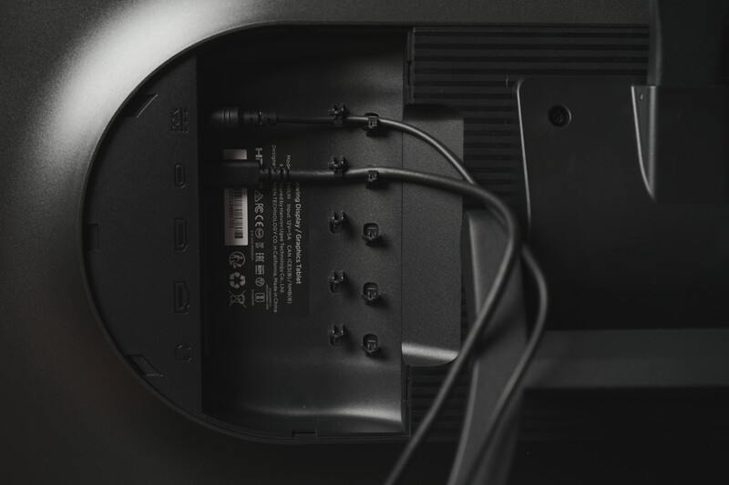 Rear view of electronic device showing connection ports and bundled cables in monochrome lighting.