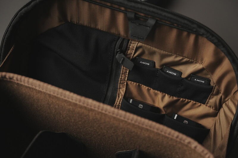 Sony camera batteries and accessories organized in a padded camera bag with bronze-toned interior lining.