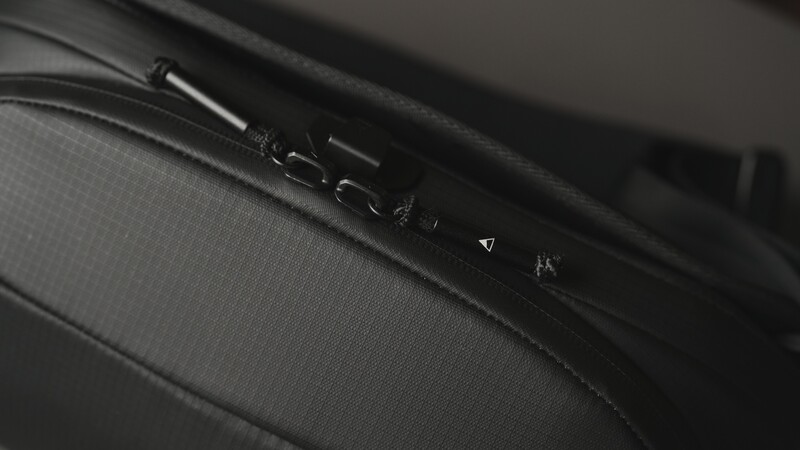 Close-up of camera controls on a textured black surface, showing buttons and dials in sharp focus with shallow depth of field.