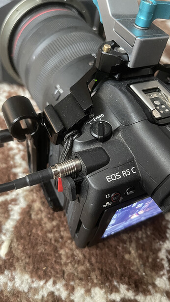Canon EOS R5 C mirrorless camera with RF lens mounted, displayed on textured fabric surface.