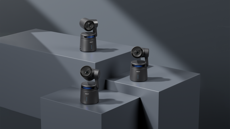Three compact camera modules with rotating lens heads positioned on stepped gray platforms with dramatic side lighting.