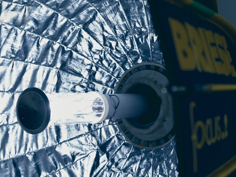 Close-up of a spacecraft docking mechanism with reflective gold thermal blanket and cylindrical coupling ports.