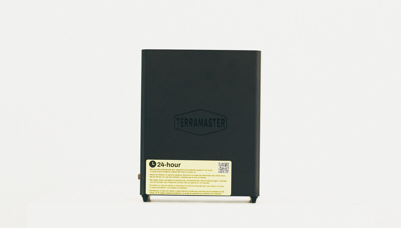 TerraMaster NAS device with black casing and yellow 24-hour warranty label on front.
