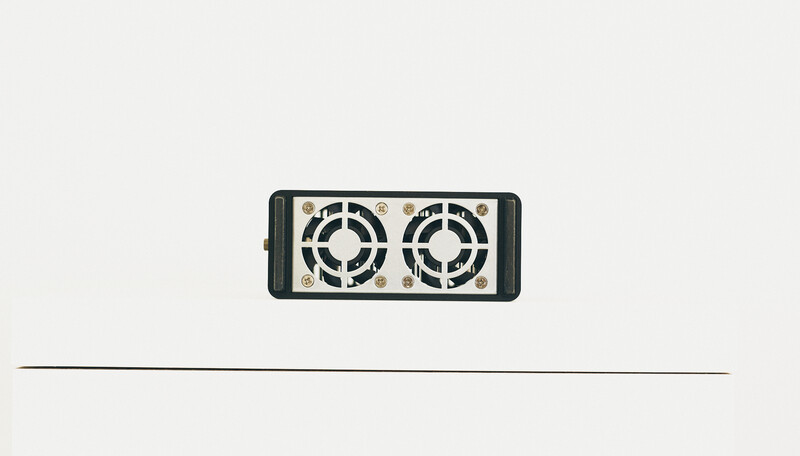 Illustration of a dual-fan external cooling device with black housing and circular ventilation grilles.
