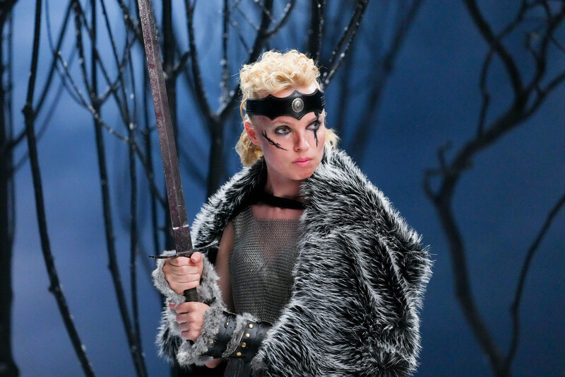 Model holding sword on a winter photography set.