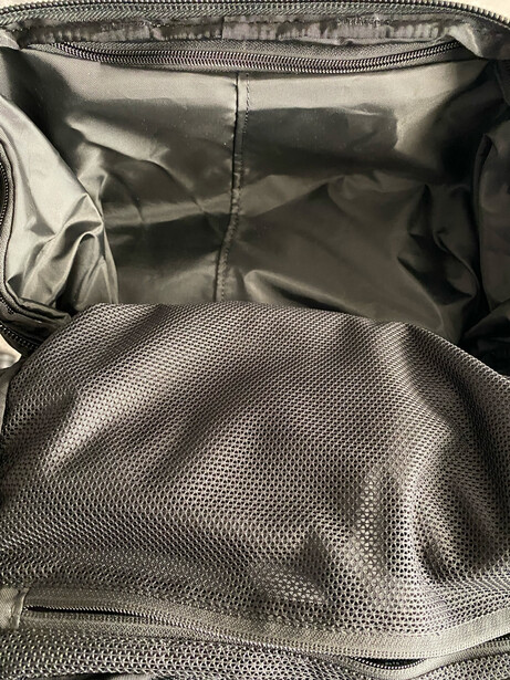 Interior view of an open camera bag with padded compartments and mesh organizer pockets.