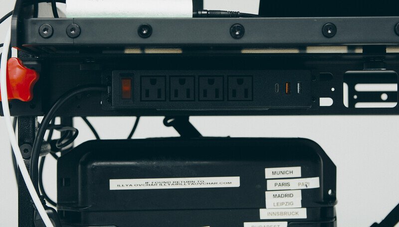 Top-down view of a power strip with multiple outlets and a coiled cable, mounted on studio equipment.