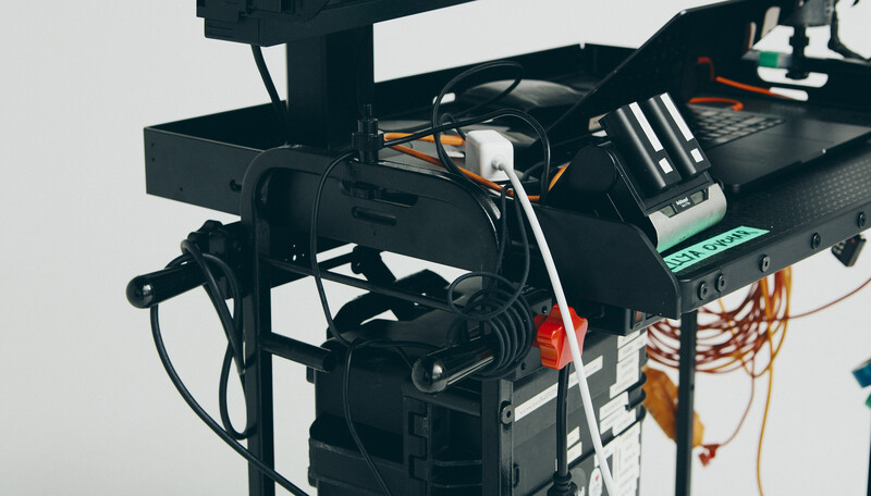 Professional lighting rig with mounted fixture, cables, and control equipment on overhead boom.