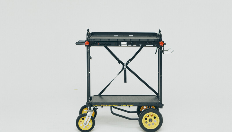 Studio photography cart with black frame, yellow and black wheels, and X-braced support structure.