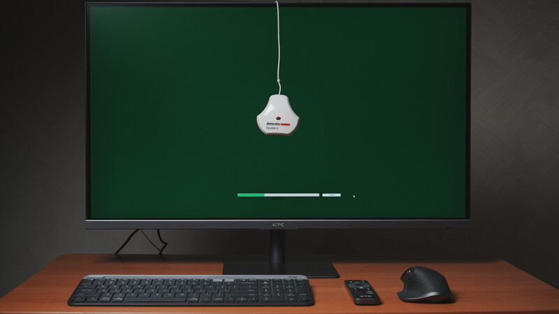 Desktop workspace with monitor displaying a pendant light illustration and loading bar against green background.
