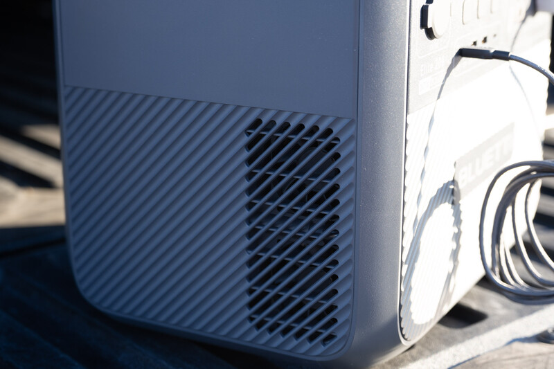 Close-up of a portable air purifier's ventilation grille and housing in bright sunlight.
