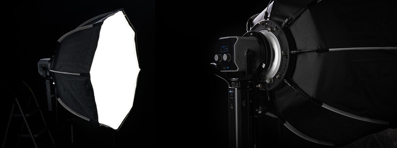 Two professional studio lights with softbox and reflector modifiers against a black background.