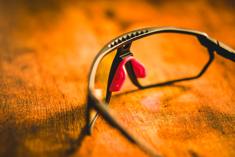 Red earbuds with cable draped on an orange textured fabric surface.