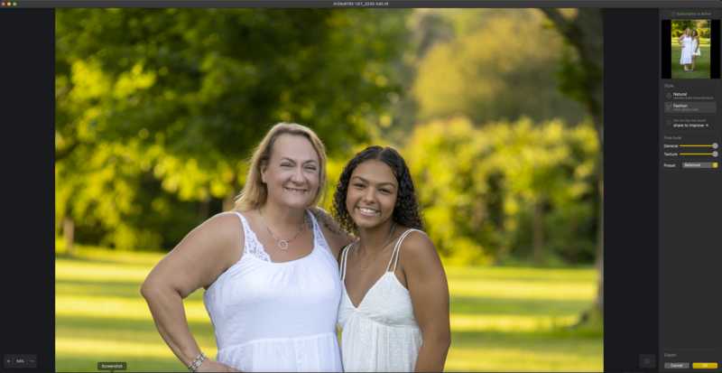 Two women smiling at camera outdoors with bright green foliage background.