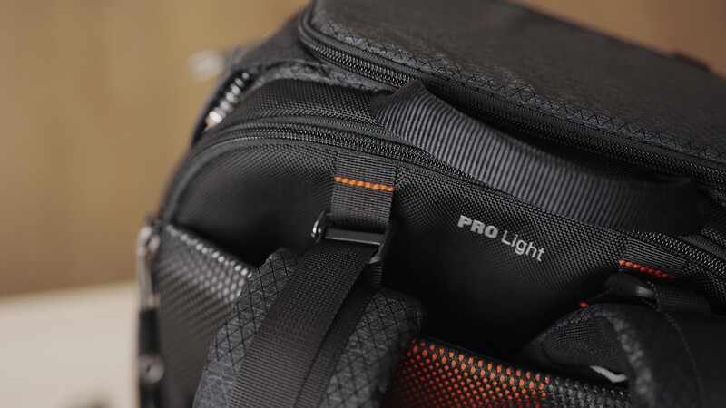 Close-up of a black camera bag with orange accents and Pro Light branding visible on the front pocket.