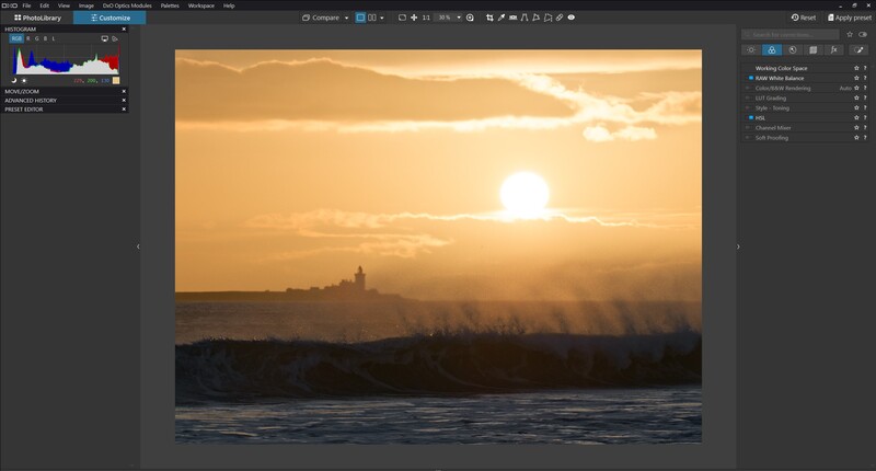 Golden sunset over a frozen river with a distant silhouetted cityscape and dramatic cloud formations.