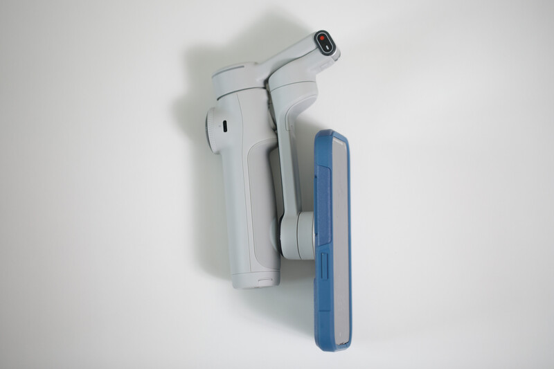 White and blue thermal imaging camera mounted on wall bracket against neutral background.
