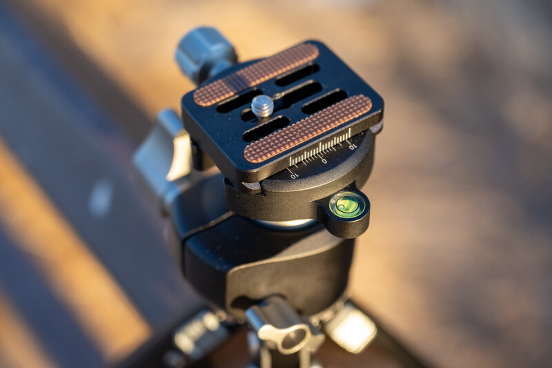 Ball head tripod mount with quick-release plate and bubble level in golden sunlight.