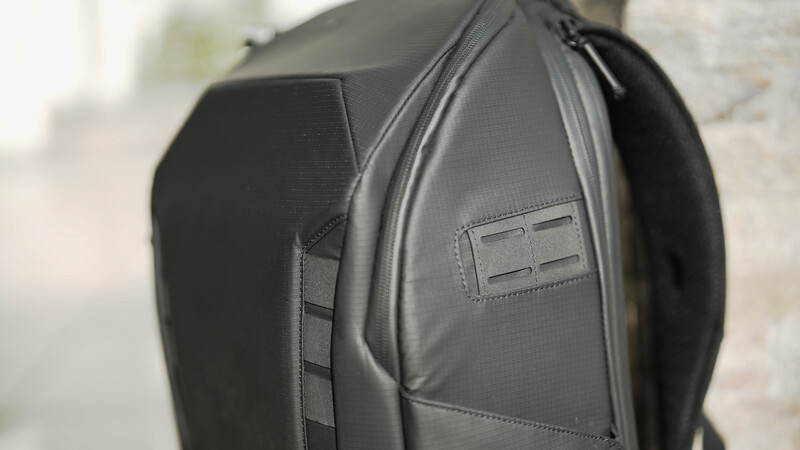 Close-up of a dark gray camera backpack showing modular compartments and padded construction.