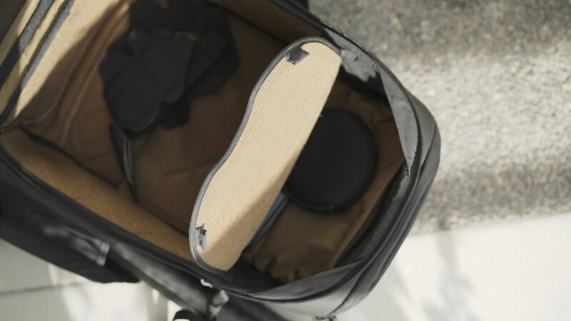 Top-down view of an open camera bag with cream-colored interior padding and black compartments.