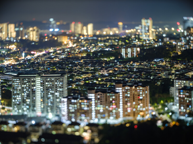 Cityscape at night with selective focus effect creating a miniature tilt-shift appearance.