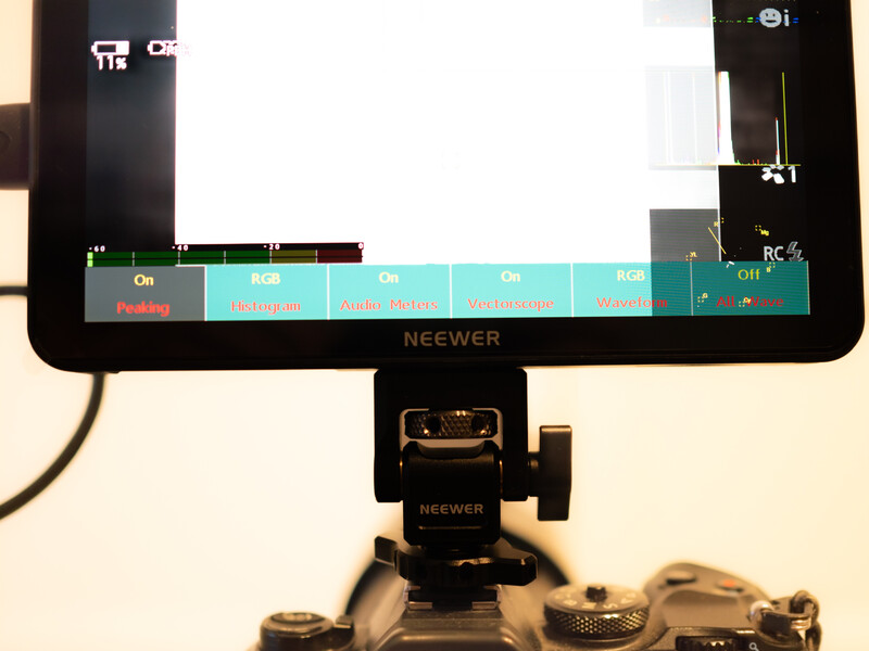 Neewer camera monitor mounted on tripod showing menu interface with teal-colored control tabs.