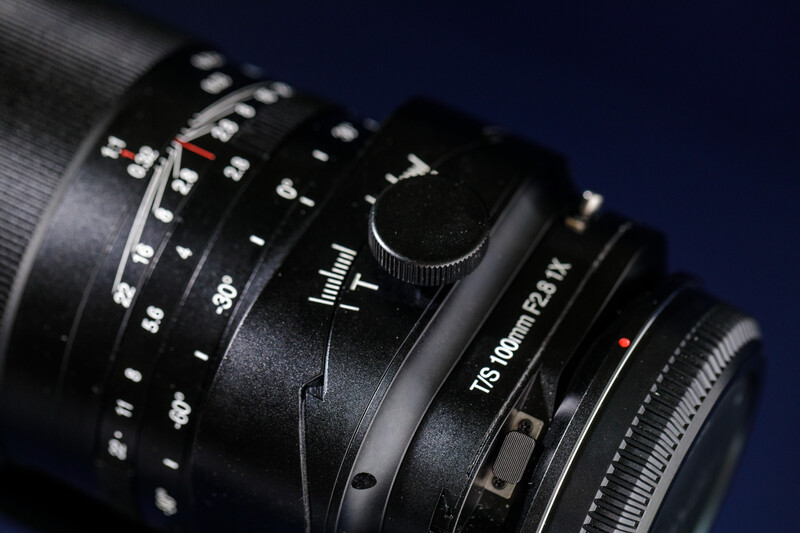 Close-up of vintage manual focus camera lenses with depth of field markings and aperture rings.