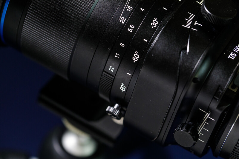 Close-up of a manual focus lens showing aperture and distance scale markings with shallow depth of field.