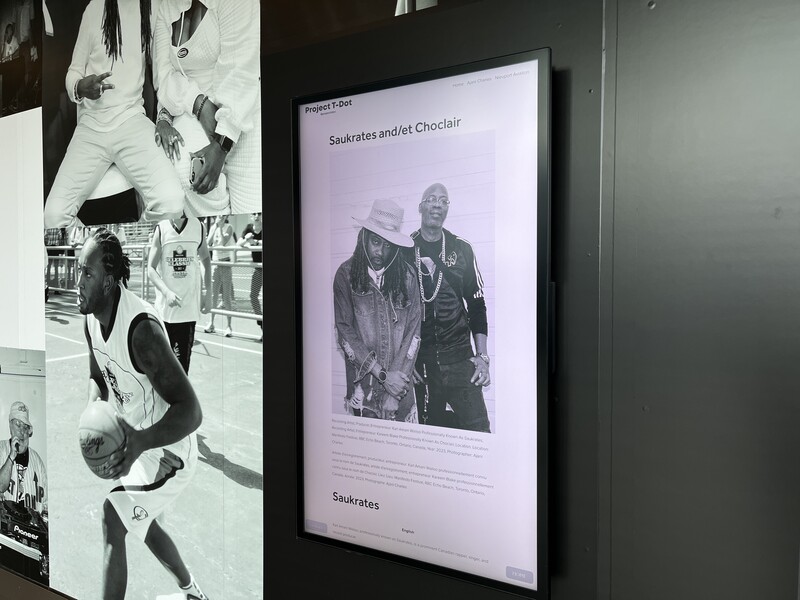 Gallery wall displaying black and white portrait photography with framed prints and exhibition text.