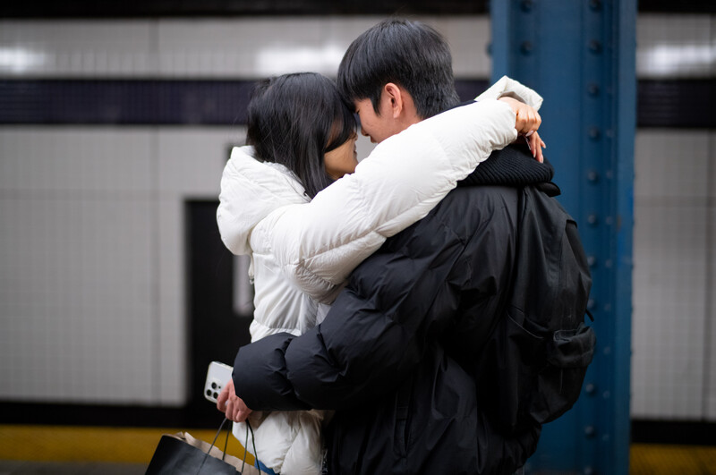Couple embracing in a subway station.